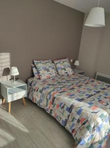 Villa Romane في أوبينا: غرفة نوم مع سرير مع لحاف ووسائد ملونة