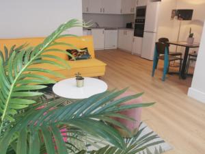 a living room with a yellow couch and a table at 360 Town Stay Apartments & Studios in Dungarvan