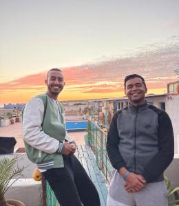 dos hombres parados en la parte superior de un balcón en Surf HouseMaroc, en Essaouira
