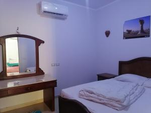 a bedroom with a bed and a dresser and a mirror at Dahab Bay hotel in Dahab