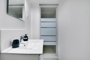 a white bathroom with a sink and a mirror at CMG - Passy - La Muette in Paris