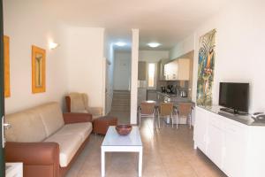 a living room with a couch and a table and a kitchen at Westhaven Bay in Costa Del Silencio