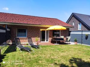 two chairs and an umbrella in the yard of a house at Ferienwohnung "Am Radweg" in Telgte