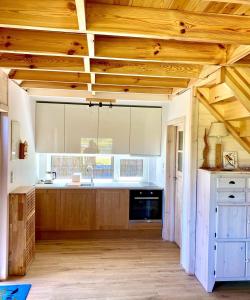 a kitchen with wooden ceilings and a large kitchen with wooden cabinets at Przystań Sielachowskie 