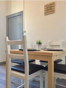 een eettafel met 2 stoelen en een houten tafel bij Charmant T2 proche vieille ville in Montluçon