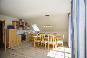 une cuisine avec une table et des chaises dans une pièce dans l'établissement nah am Meer, Meerblick, gratis Nutzung vom AHOI Erlebnisbad und Sauna in Sellin - Haus Inselblick FeWo 03, à Göhren