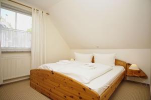 - un lit en bois dans une chambre avec fenêtre dans l'établissement nah am Meer, Meerblick, gratis Nutzung vom AHOI Erlebnisbad und Sauna in Sellin - Haus Inselblick FeWo 03, à Göhren 19 autres photos