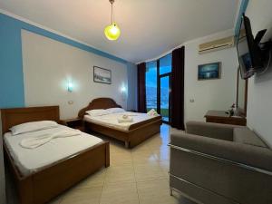 ein Hotelzimmer mit 2 Betten und einem Sofa in der Unterkunft Hotel Bahamas in Sarandë