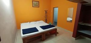 a bed in a room with an orange wall at Coorg girinivas homestay 102 in Madikeri