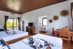 a bedroom with two beds and a desk and a television at Maya Resort Samui - Family resort-Sha Plus Extra in Bophut