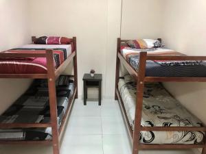 a room with two bunk beds and a table at Colibrí Hostel in Puerto Iguazú