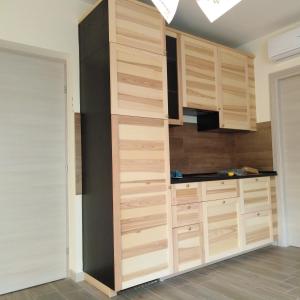 una cocina con armarios de madera en una habitación en LA CASA DEL GUARDIA, en Lonedo