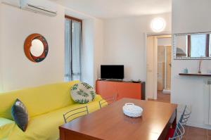 a living room with a yellow couch and a wooden table at Casa Sole in Novate Mezzola