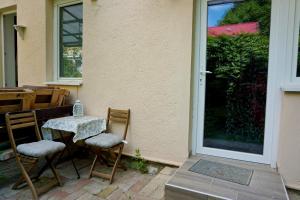 a table and chairs sitting outside of a house at Tündér Róza Apartman in Miskolctapolca