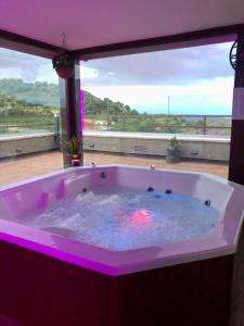 Un jacuzzi en una habitación con una ventana grande. en Hotel Boutique Abadia del Maestrat, en Serratella (Sarratella)