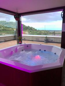 a hot tub in a room with a large window at Hotel Boutique Abadia del Maestrat in Sarratella