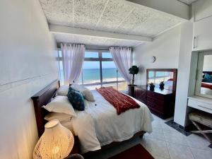 a bedroom with a bed with a view of the ocean at Sea View Penthouse in Ballito