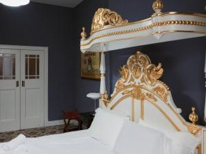 1 cama con dosel blanco y dorado en una habitación en Pass the Keys Artistic and Stylish 2 Bedroom Flat in City Centre, en Glasgow