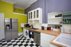 a kitchen with white cabinets and a checkered floor at Pass the Keys Artistic and Stylish 2 Bedroom Flat in City Centre in Glasgow