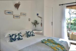 a bedroom with a bed with pillows and a window at Lodge de Charme A Cheda in Bonifacio