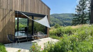 een huis met een patio met een tafel en stoelen bij Domek na wzgórzu 