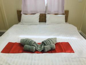 a bed with two towels on top of it at Sukanya Guesthouse 
