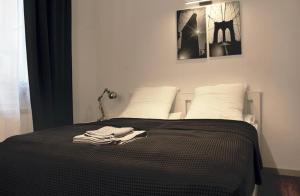 a bed with a black blanket and white pillows at Elegant apartment in the center of Sofia in Sofia