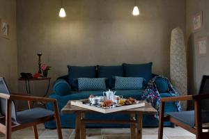 a living room with a blue couch and a table at Lodge de Charme A Cheda in Bonifacio