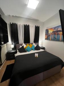 una camera da letto con un grande letto con cuscini neri e gialli di Hotel Granus ad Aquisgrana