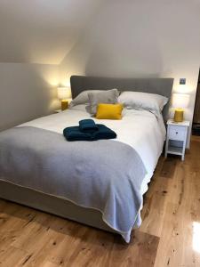 1 dormitorio con 1 cama grande con almohadas amarillas en The Hive - beautiful studio with amazing hot tub en Cratfield