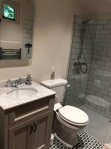 y baño con aseo, lavabo y ducha. en The Hive - beautiful studio with amazing hot tub en Cratfield