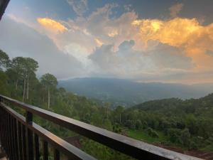 a view of a valley from a wooden railing with a view at AK Hotel & Suites in Murree