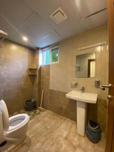 a bathroom with a toilet and a sink at AK Hotel & Suites in Murree