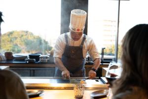 Een man in een koksmuts die eten klaarmaakt in een keuken. bij Iberostar Selection Llaut Palma- Adults Only in Playa de Palma