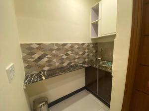 a small kitchen with a sink and a counter top at AK Hotel & Suites in Murree
