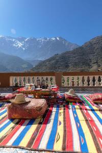a room with a colorful rug with mountains in the background at Amazigh Family Riad in Imlil