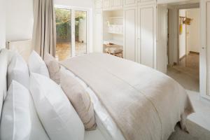 1 dormitorio con cama blanca y almohadas blancas en Haus Janus 1 - Wohnung 1, en Norderney