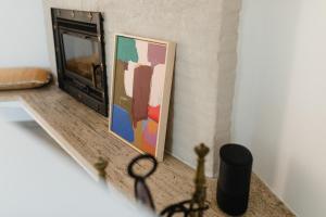 a framed painting on a table next to a fireplace at Haus Janus 1 - Wohnung 1 in Norderney