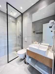 a bathroom with a sink and a toilet and a shower at Le Rêve Boutique Hotel in Dhërmi