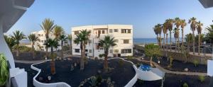 an aerial view of a resort with palm trees and the ocean at Strandapartment Costa Luz-Ozean View in Tías