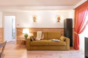 - un salon avec un canapé et une télévision dans l'établissement 13 Comuni Ristorante E Albergo, à Velo Veronese
