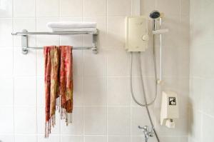 e bagno con termoarredo e doccia. di Asphodel Inn a Singapore