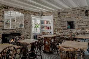 um restaurante com mesas e cadeiras e uma parede de tijolos em The Olde Malthouse Inn em Tintagel