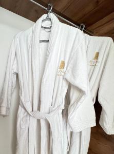 a white robe is hanging on a rack at Le Rêve Boutique Hotel in Dhërmi