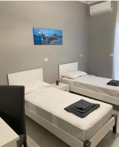 een slaapkamer met 2 bedden en een tafel en een schilderij bij B&B Blu Krimisa in Cirò Marina