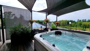bañera de hidromasaje en la terraza de un balcón en Hotel Spa Laskowo, en Jankowice