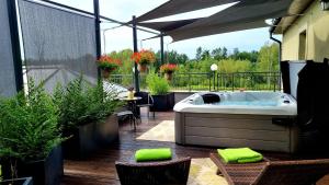un patio con bañera en un balcón con plantas en Hotel Spa Laskowo, en Jankowice
