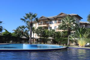 a resort with a large swimming pool and palm trees at Cumbuco - VGSun Apartment 402 in Cumbuco