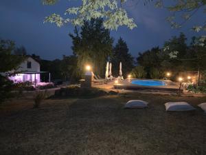 a backyard with a swimming pool at night at Le grain de Louise in Corcelles-en-Beaujolais
