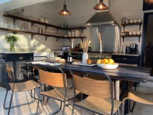 una cocina con una gran mesa de madera con sillas en Old School House - Luxury 4 bed holiday home near Norwich, Norfolk en Lingwood